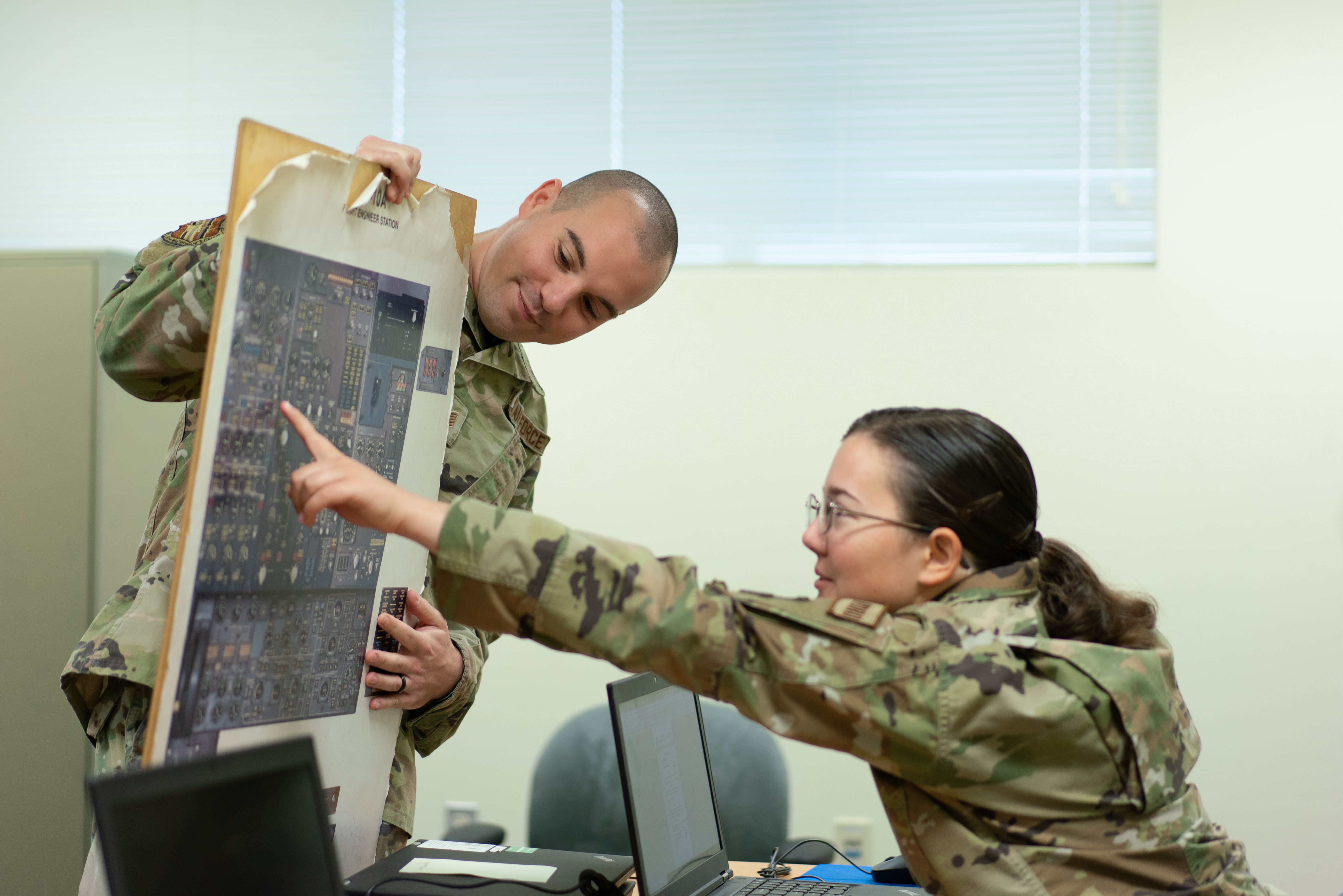 Two student pointing at an instructional board
